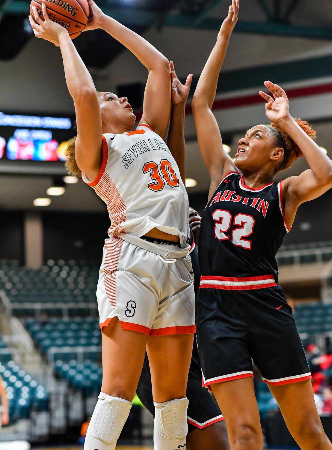 Katy Tx. Feb 22, 2022:  Seven Lakes Justice Carlton #30 goes up for the shot guarded by Fort Bend Austins Gabrielle Johnson #22 during the Regional Quarterfinal playoff game, Seven Lakes vs Fort Bend Austin at the Merrell Center. (Photo by Mark Goodman / Katy Times)
