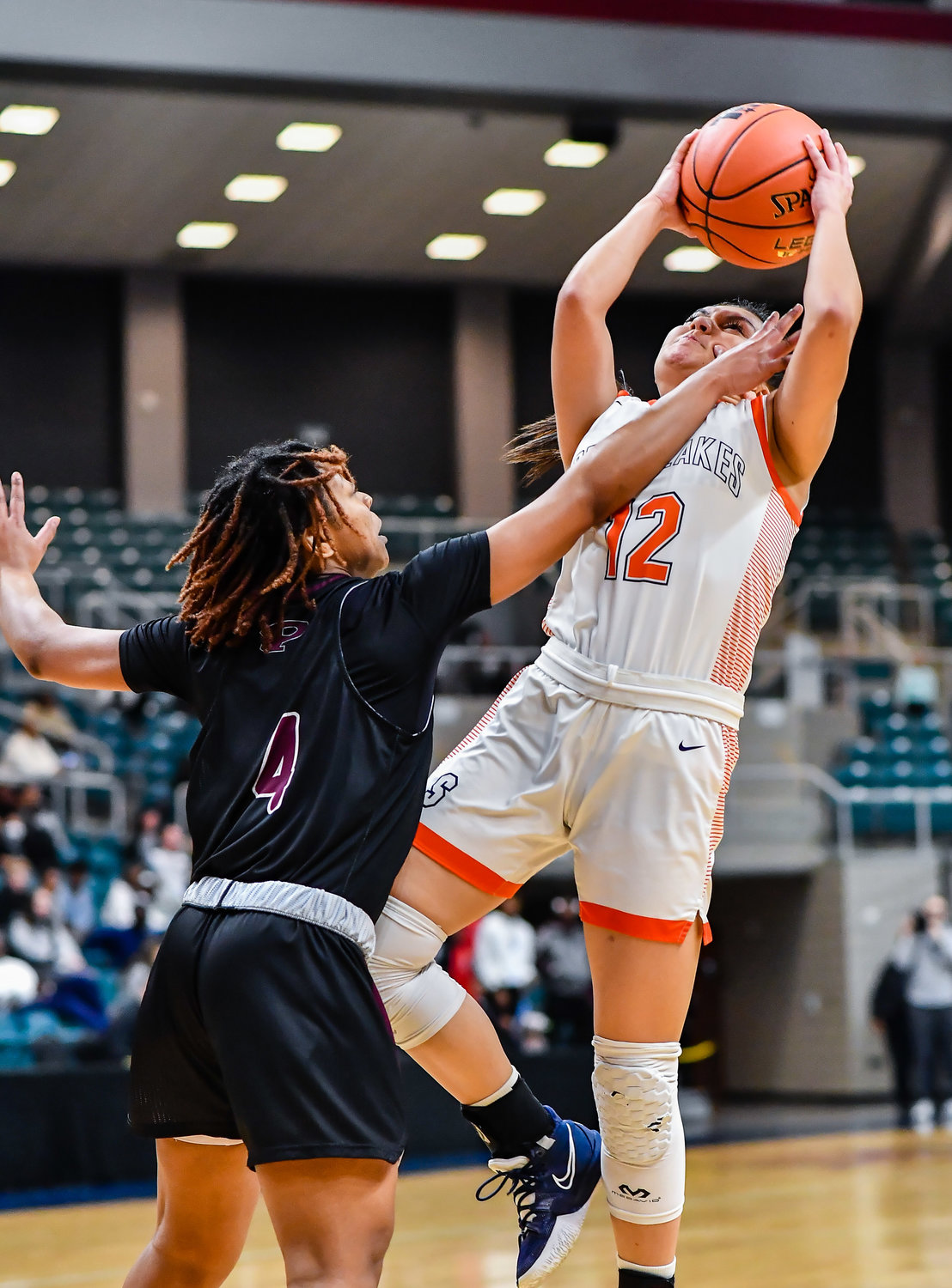 Katy Tx. Feb 25, 2022:  Seven Lakes Cailyn Tucker #12 drives to the basket guarded by Pearlands Paige Bonner #4 during the Regional SemiFinal playoff game, Seven Lakes vs Pearland at the Merrell Center. (Photo by Mark Goodman / Katy Times)