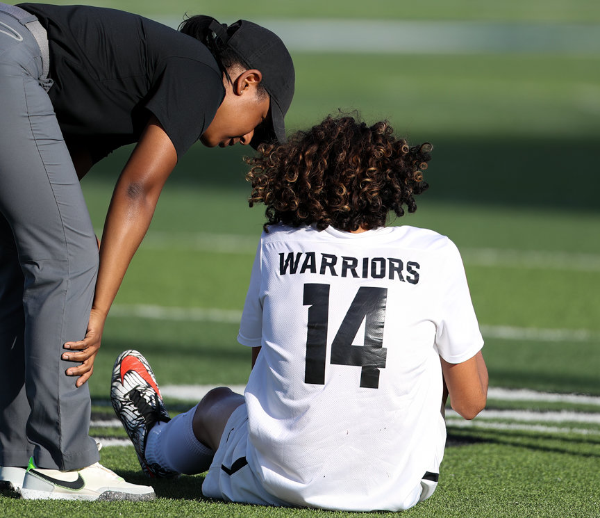 A team trainer comes over to check on Jordan forward Noah Betancourt (14), who left the game late in the first half following an injury, in the Class 5A boys state semifinal between Dripping Springs and Katy Jordan on April 14, 2022 in Georgetown, Texas.