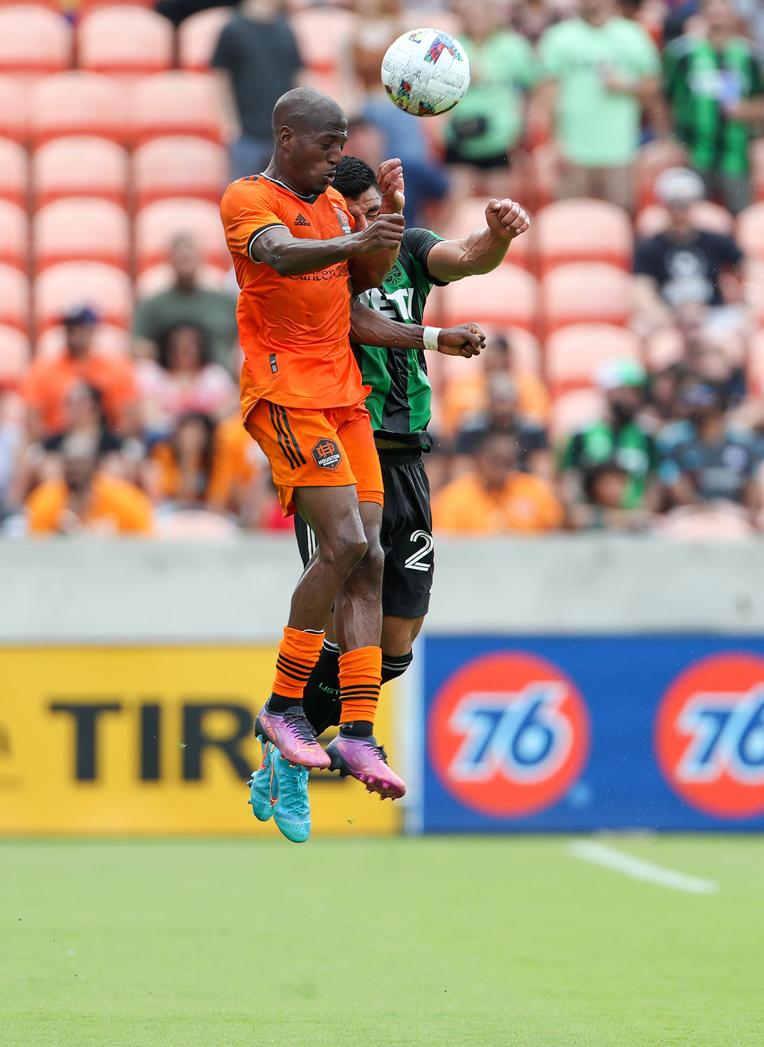 Houston Dynamo midfielder Fafà Picault (10) leaps to head the ball over Austin FC defender Nick Lima (24) during the first half of a Major League Soccer match on April 30, 2022 in Houston, Texas.