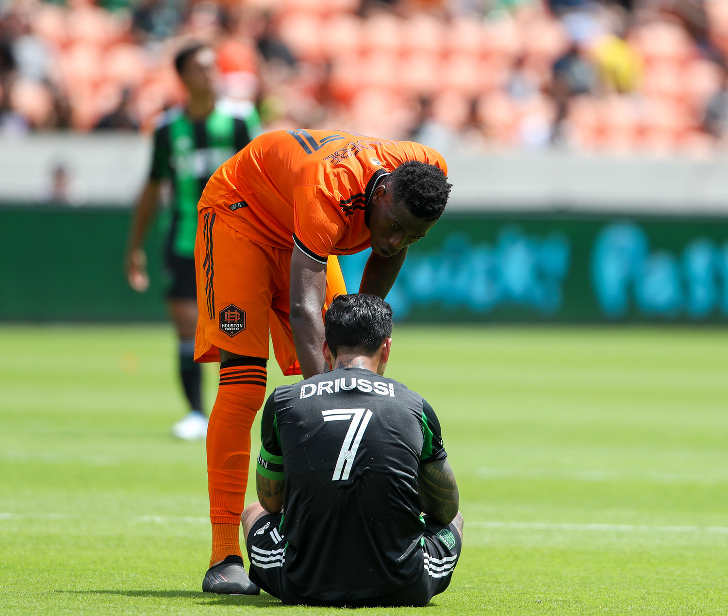 Houston Dynamo defender Teenage Hadebe (17) comes over to check on Austin FC forward Sebastián Driussi (7) during the second half of a Major League Soccer match on April 30, 2022 in Houston, Texas.