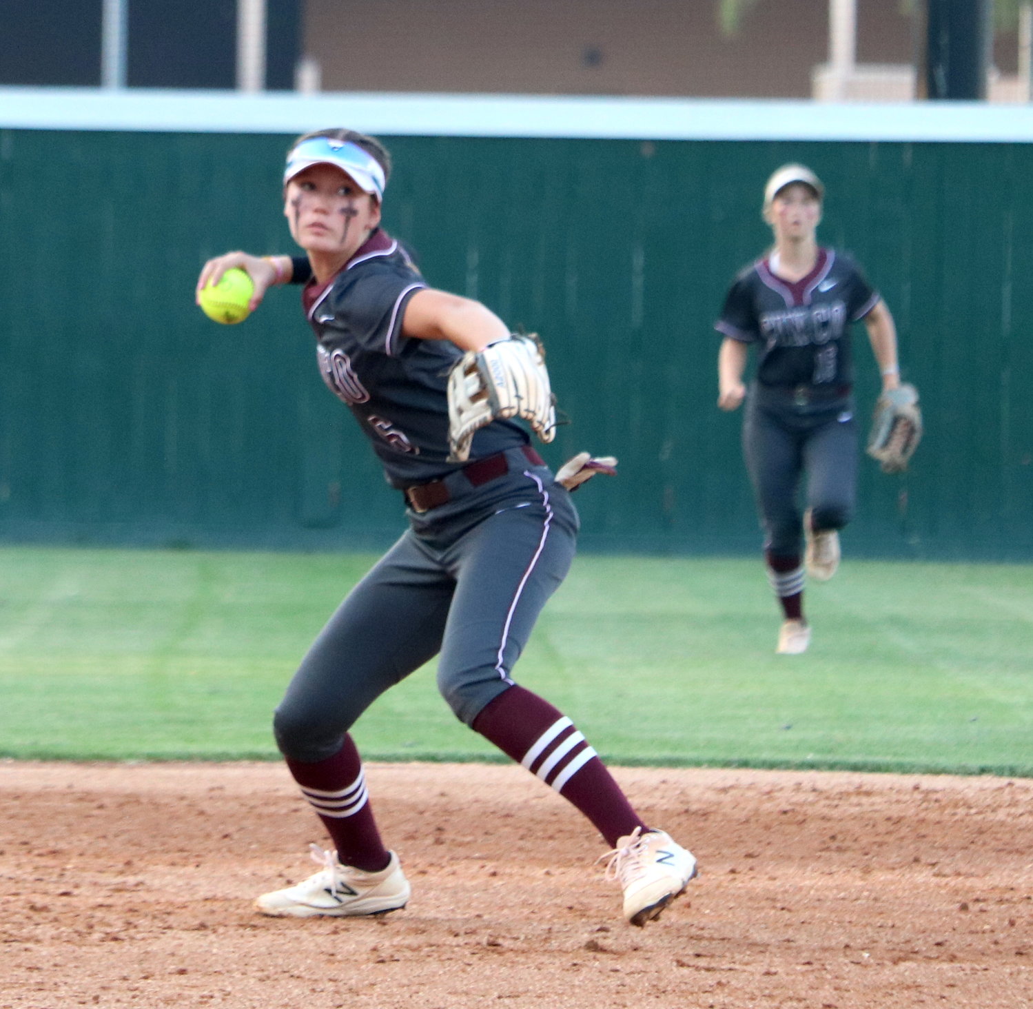 Faith Piper throws a ball to first base during Friday's area round game between Cinco Ranch and Heights at Memorial High School