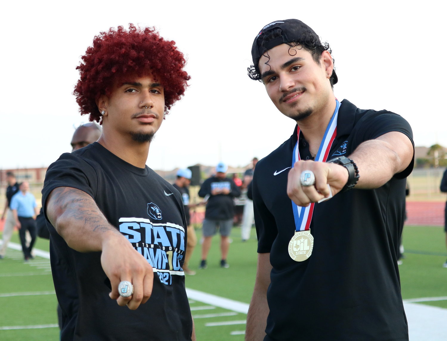 Jacob Brown and Anthony Fuentes show off their championship rings during Thursday’s ring ceremony at Paetow.