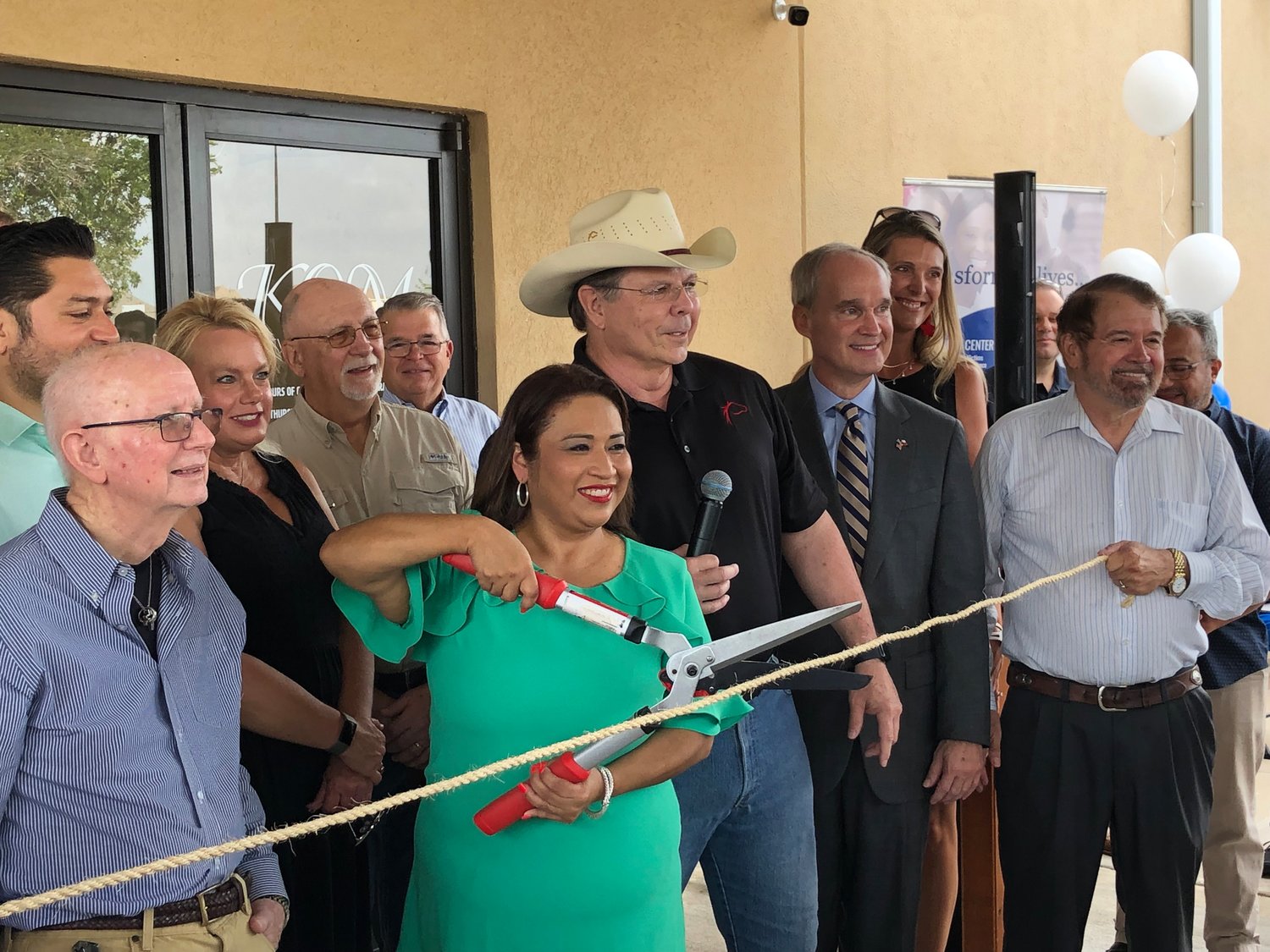 Deysi Crespo prepares to cut the ceremonial rope provided by the Fulshear Katy Area Chamber of Commerce. Don McCoy, chamber president, stands with State Rep. Mike Schofield
