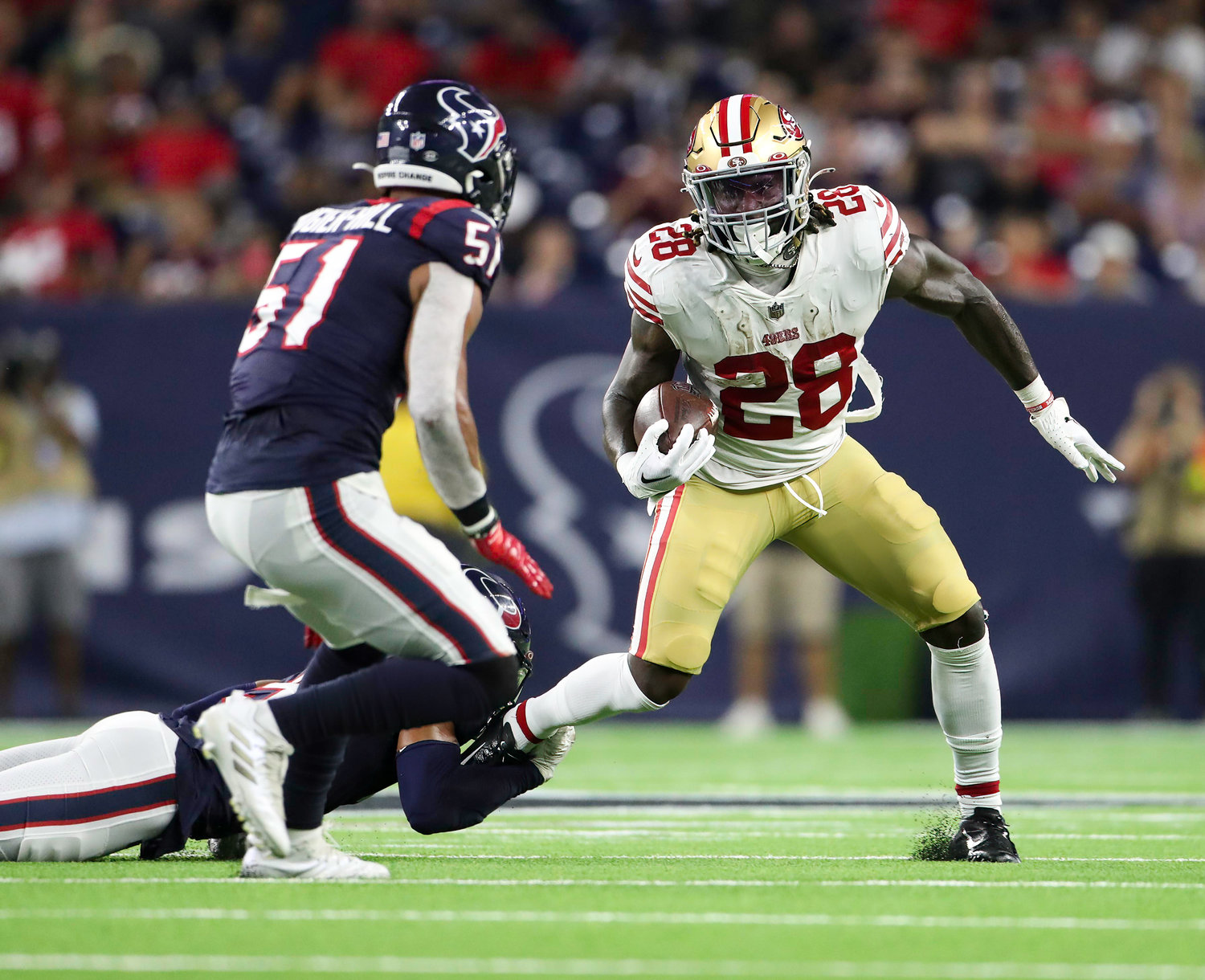San Francisco 49ers running back Trey Sermon (28) attempts to break a tackle by Houston Texans safety Jalen Pitre (5) during an NFL preseason game between the Texans and the 49ers in Houston, Texas, on August 25, 2022.