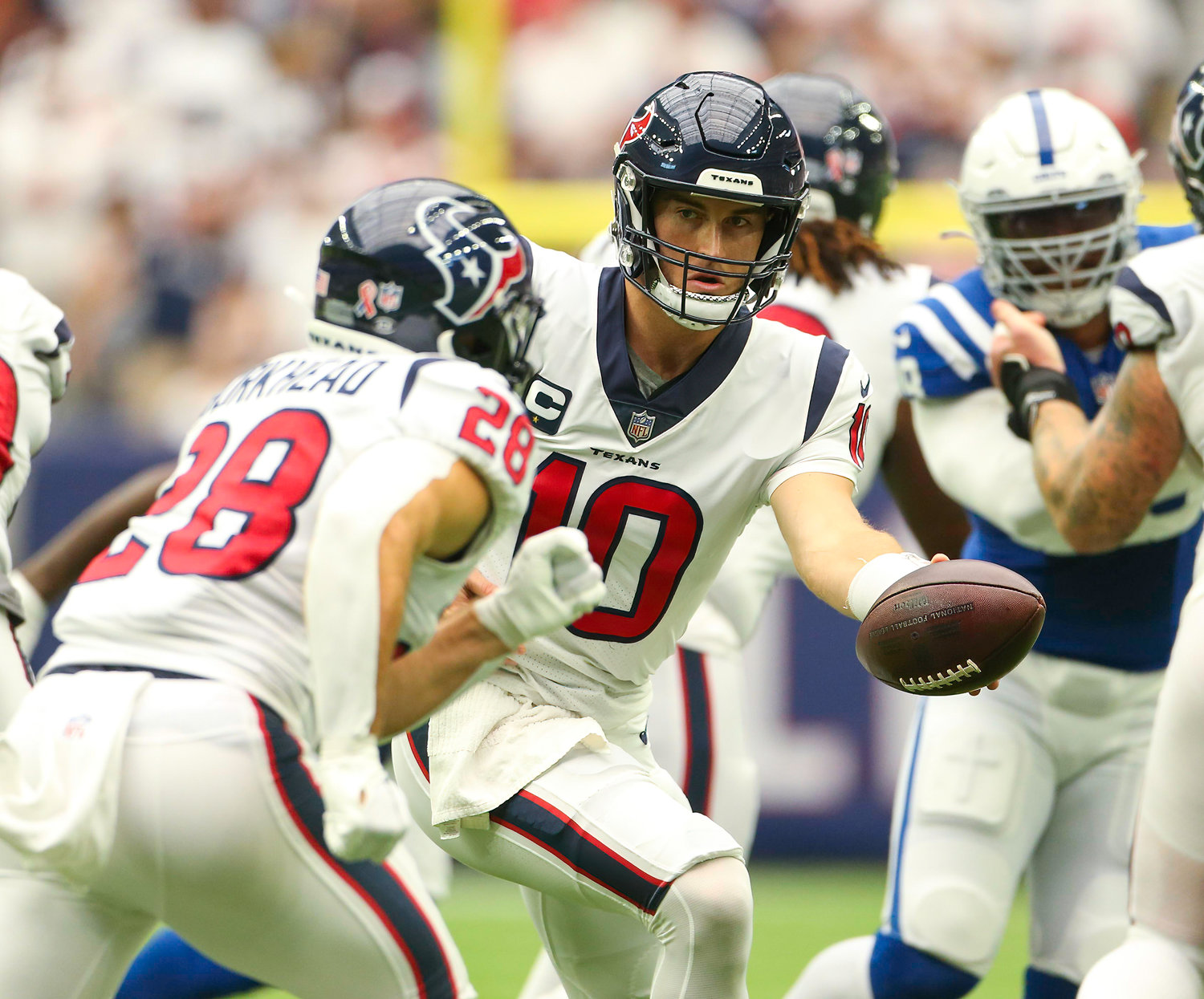 Houston Texans quarterback Davis Mills (10) hands the ball off to running back Rex Burkhead (28) during an NFL game between the Texans and the Colts on September 11, 2022 in Houston. The game ended in a 20-20 tie after a scoreless overtime period.