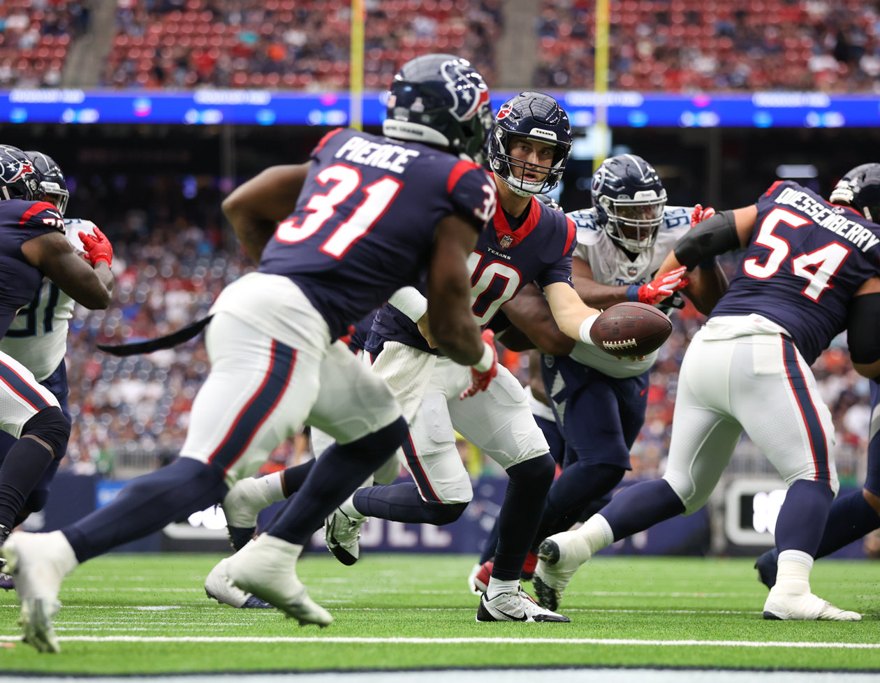 Texans quarterback Davis Mills (10) hands the ball off to running back Dameon Pierce (31) in his own end zone during an NFL game between the Texans and the Titans on Oct. 30, 2022 in Houston.