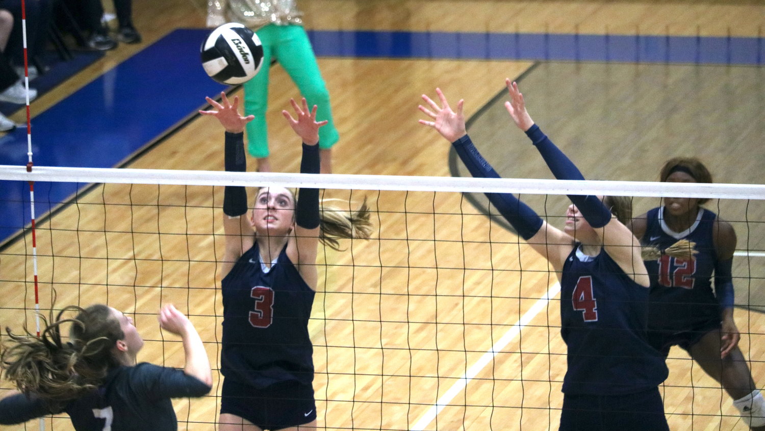 Presley Powell and Callie Funk attempt to block a kill attempt during Tuesday's match between Tompkins and Ridge Point at Wheeler Field House.