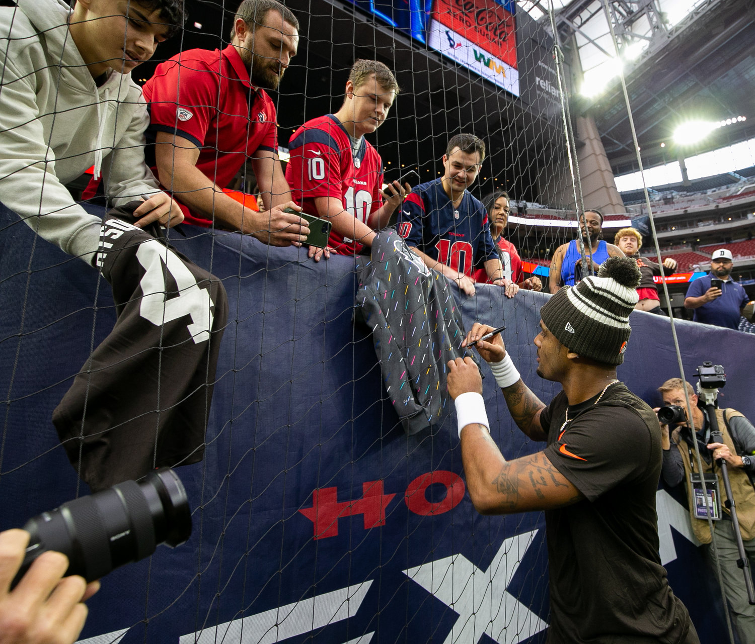 Former Houston Texans and current Cleveland Browns quarterback Deshaun Watson signs autographs before an NFL game on Dec. 4, 2022, in Houston. The game marks the controversial quarterback’s return to Houston and first game back after an 11-game suspension for allegations of sexual misconduct during his tenure with the Texans.