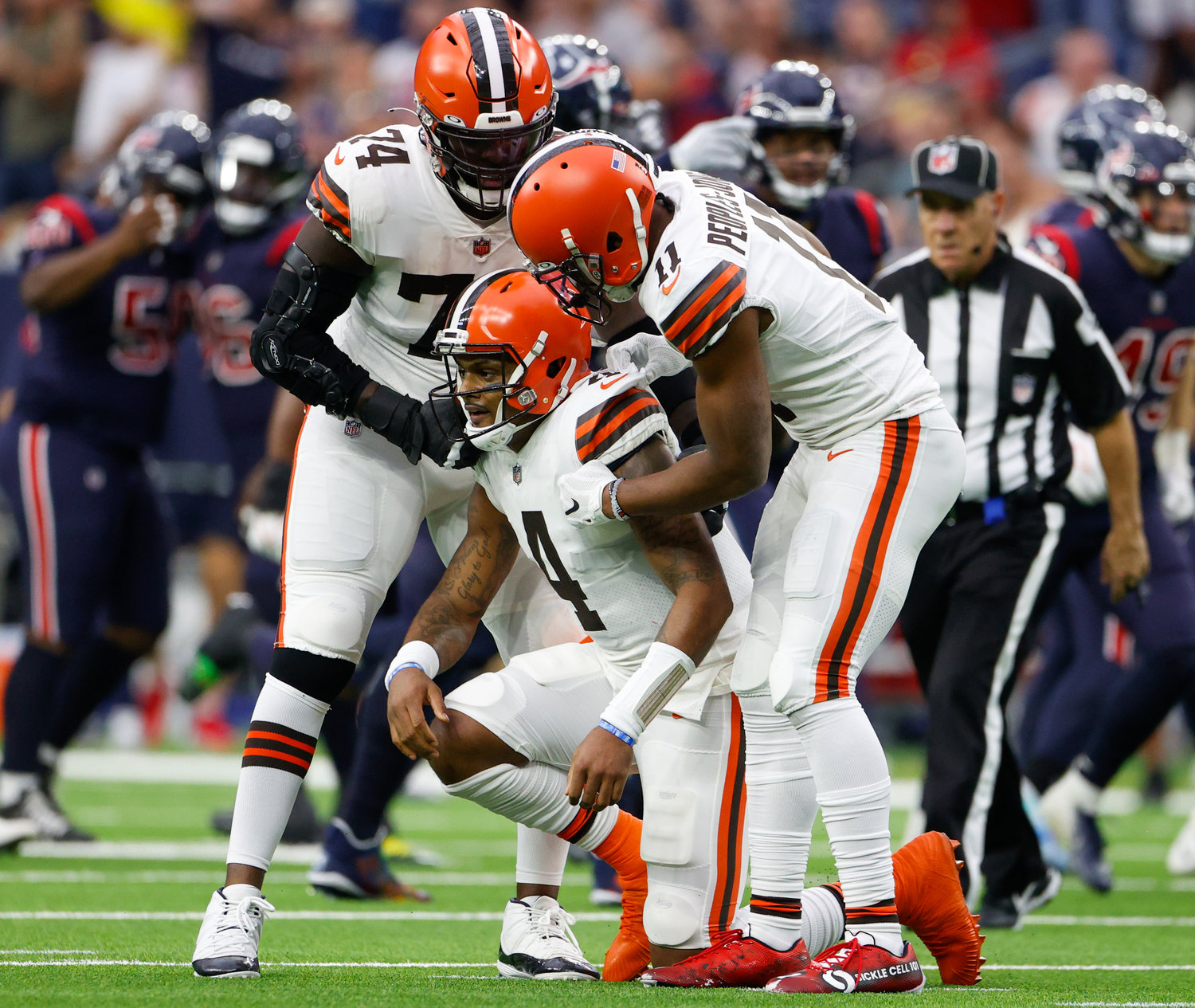 Cleveland Browns offensive tackle Chris Hubbard (74) and wide receiver Donovan Peoples-Jones (11) help quarterback Deshaun Watson (4) up after an interception during an NFL game between the Houston Texans and the Cleveland Browns on Dec. 4, 2022, in Houston. The Browns won, 27-14.