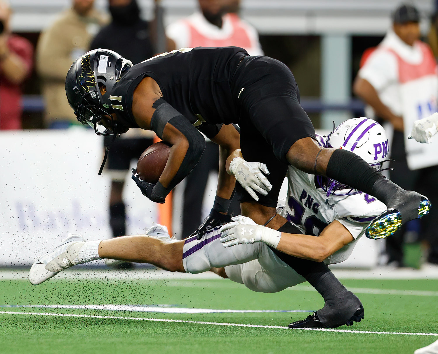 Port Neches-Groves defensive back Reid Richard (28) tackles South Oak Cliff wide receiver Jamyri Cauley (11) during the Class 5A Division II football state championship game between South Oak Cliff and Port Neches-Groves in Arlington, Texas, on Dec. 16, 2022.