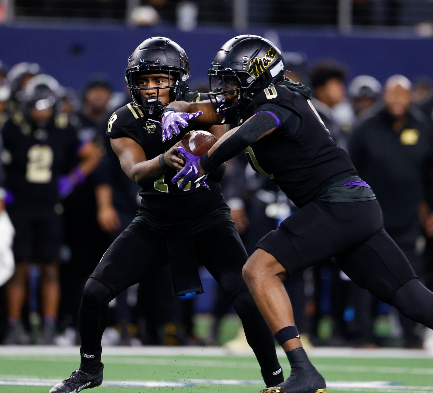 South Oak Cliff quarterback William Little (18) hands the ball off to running back Jayvon Thomas (0) during the Class 5A Division II football state championship game between South Oak Cliff and Port Neches-Groves in Arlington, Texas, on Dec. 16, 2022.