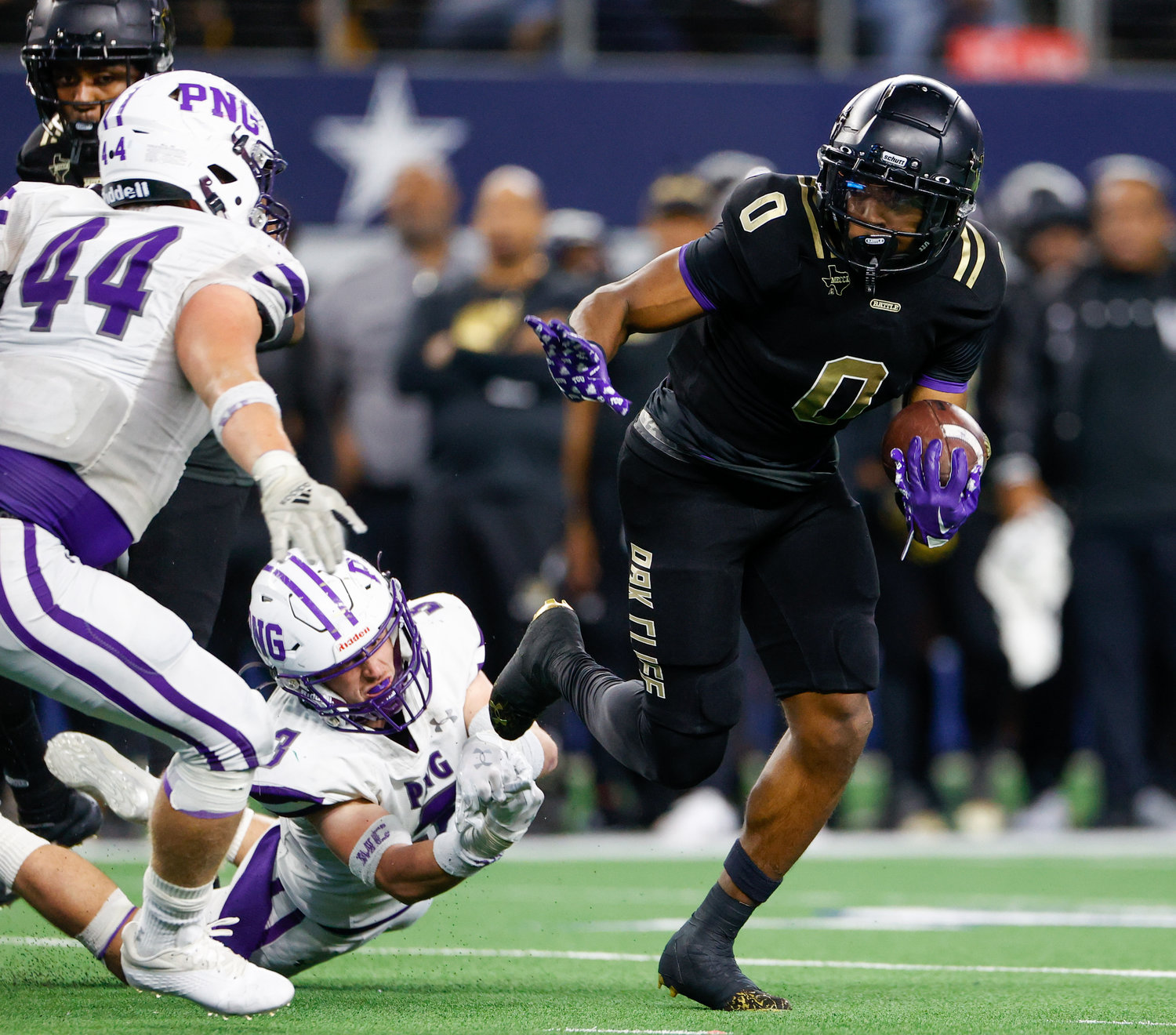 South Oak Cliff running back Jayvon Thomas (0) slips through the tackle of Port Neches-Groves linebacker Mason Droddy (3) during the Class 5A Division II football state championship game between South Oak Cliff and Port Neches-Groves in Arlington, Texas, on Dec. 16, 2022.
