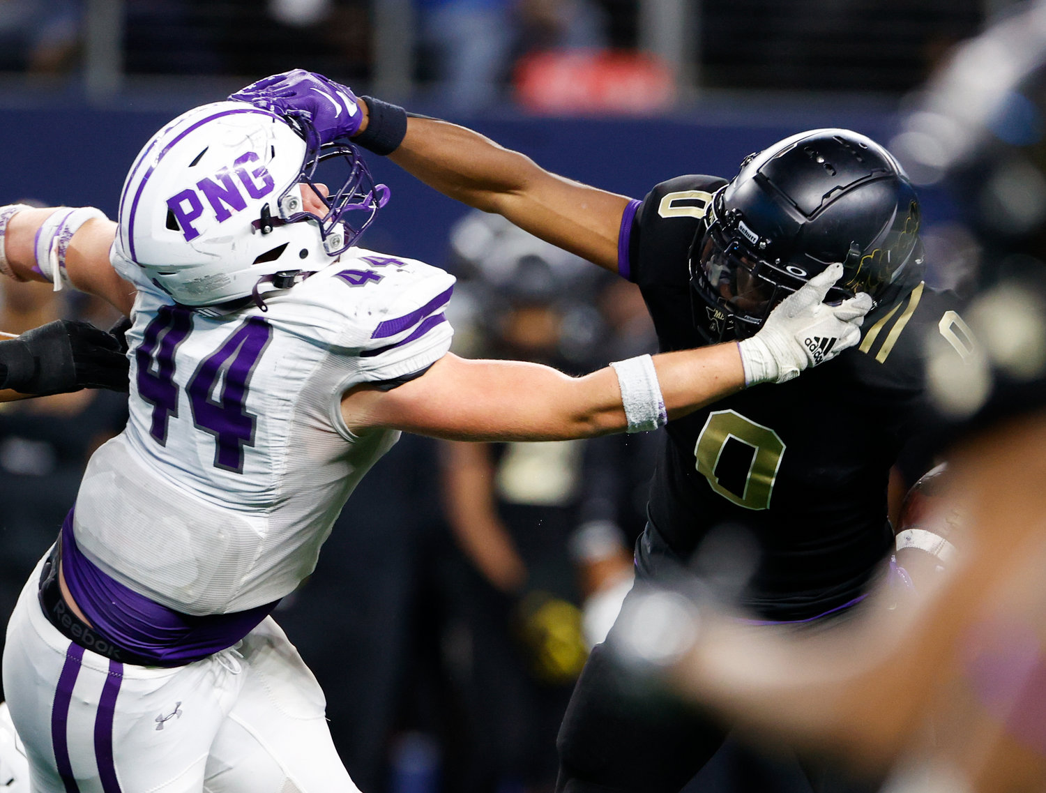 Port Neches-Groves defensive lineman Peyton Broom (44) and South Oak Cliff running back Jayvon Thomas (0) grab each other’s facemask on a carry during the Class 5A Division II football state championship game between South Oak Cliff and Port Neches-Groves in Arlington, Texas, on Dec. 16, 2022.