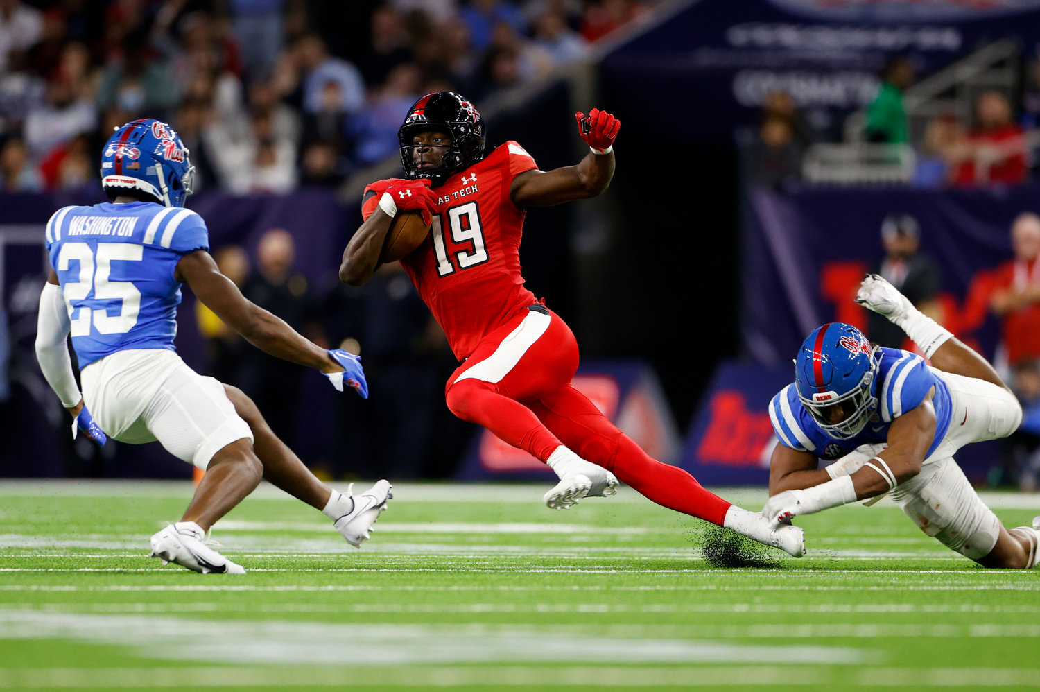 Texas Tech wide receiver Loic Fouonji (19) carries the ball after a catch and escapes the grasp of an Ole Miss defender during the TaxAct Texas Bowl on Dec. 28, 2022 in Houston.