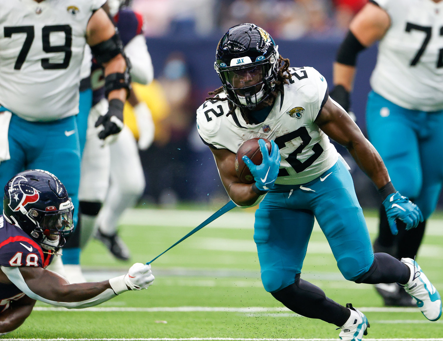 Texans linebacker Christian Harris (48) holds on and tears the jersey of Jaguars running back JaMycal Hasty (22) on a tackle attempt during an NFL game between the Houston Texans and the Jacksonville Jaguars on Jan. 1, 2023 in Houston. The Jaguars won, 31-3.
