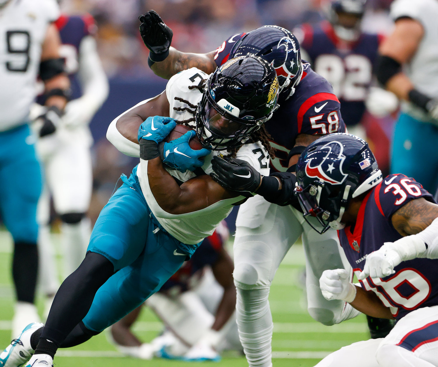 Jaguars running back JaMycal Hasty (22) is tackled by Texans safety Jonathan Owens (36) and linebacker Christian Kirksey (58) during an NFL game between the Houston Texans and the Jacksonville Jaguars on Jan. 1, 2023 in Houston. The Jaguars won, 31-3.