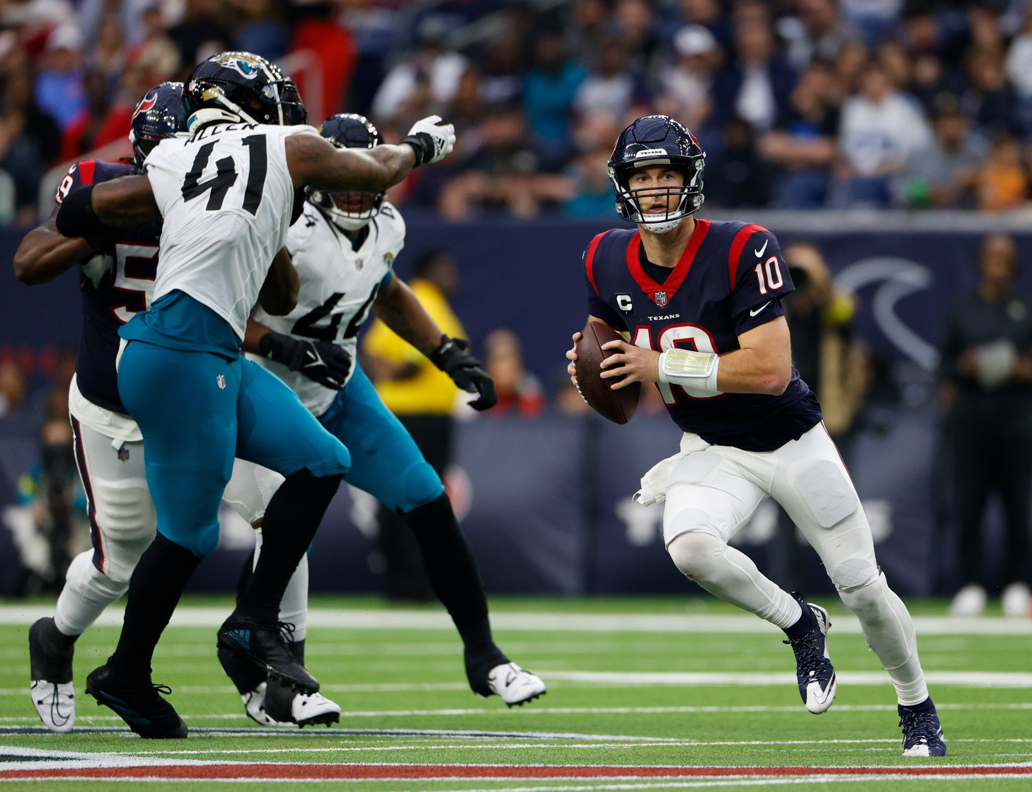 Texans quarterback Davis Mills (10) scrambles and looks downfield for a running lane during an NFL game between the Houston Texans and the Jacksonville Jaguars on Jan. 1, 2023 in Houston. The Jaguars won, 31-3.