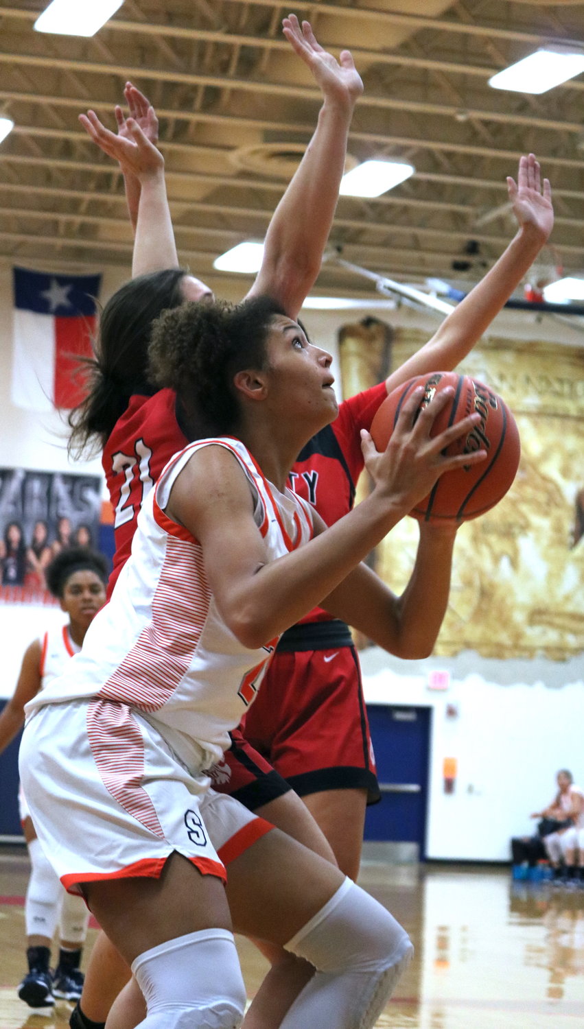 Madison Carlton gathers to go up for a shot during Tuesday's game between Katy and Seven Lakes at the Seven Lakes gym.