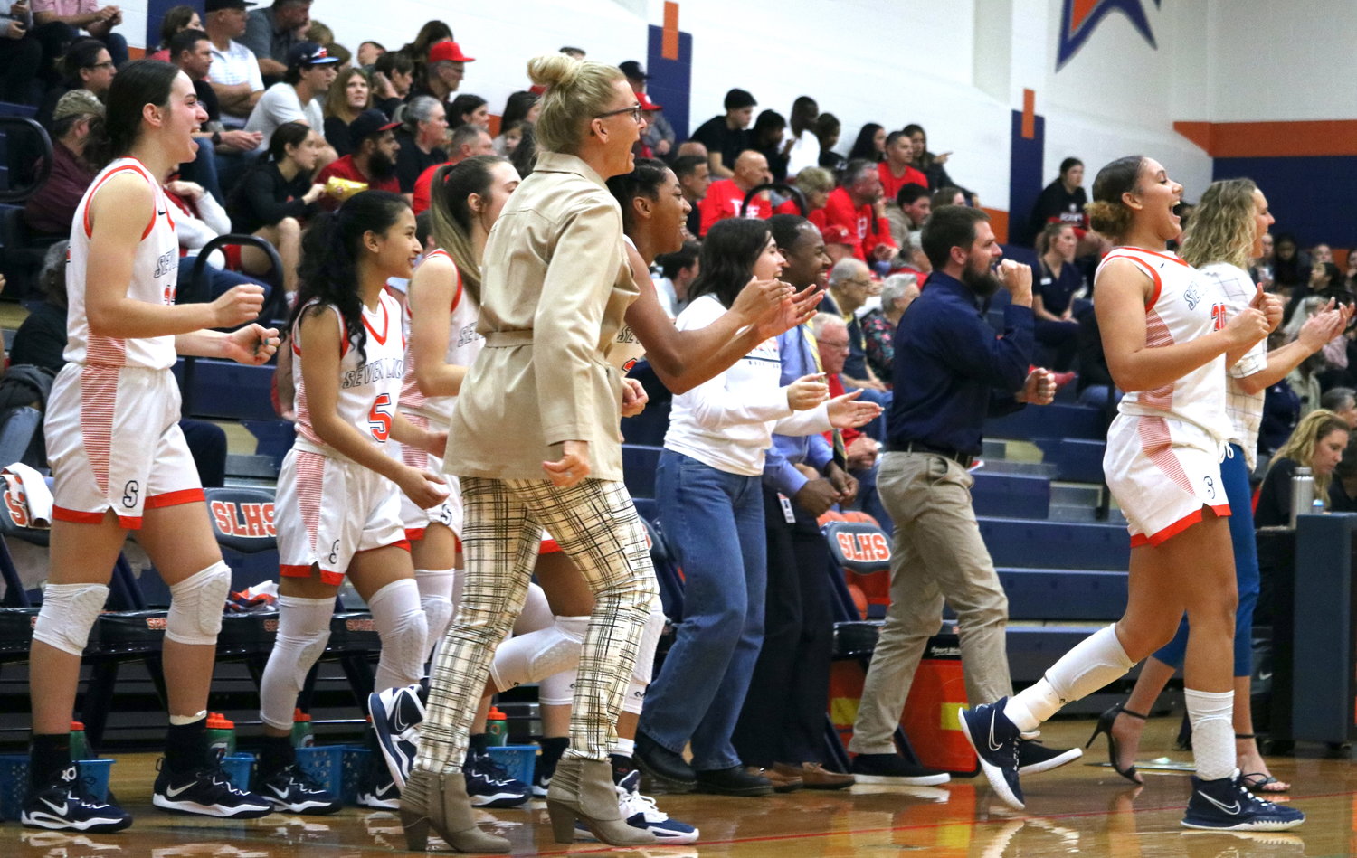 The Seven Lakes bench celebrates after the Spartans made a basket during Tuesday's game between Katy and Seven Lakes at the Seven Lakes gym.