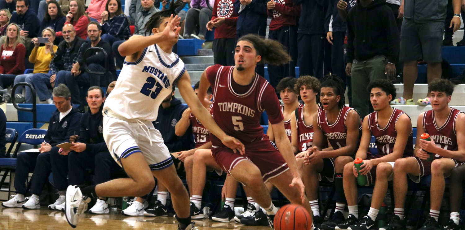 Luke Caughran drives the baseline during Saturday's game between Tompkins and Taylor at the Taylor gym.