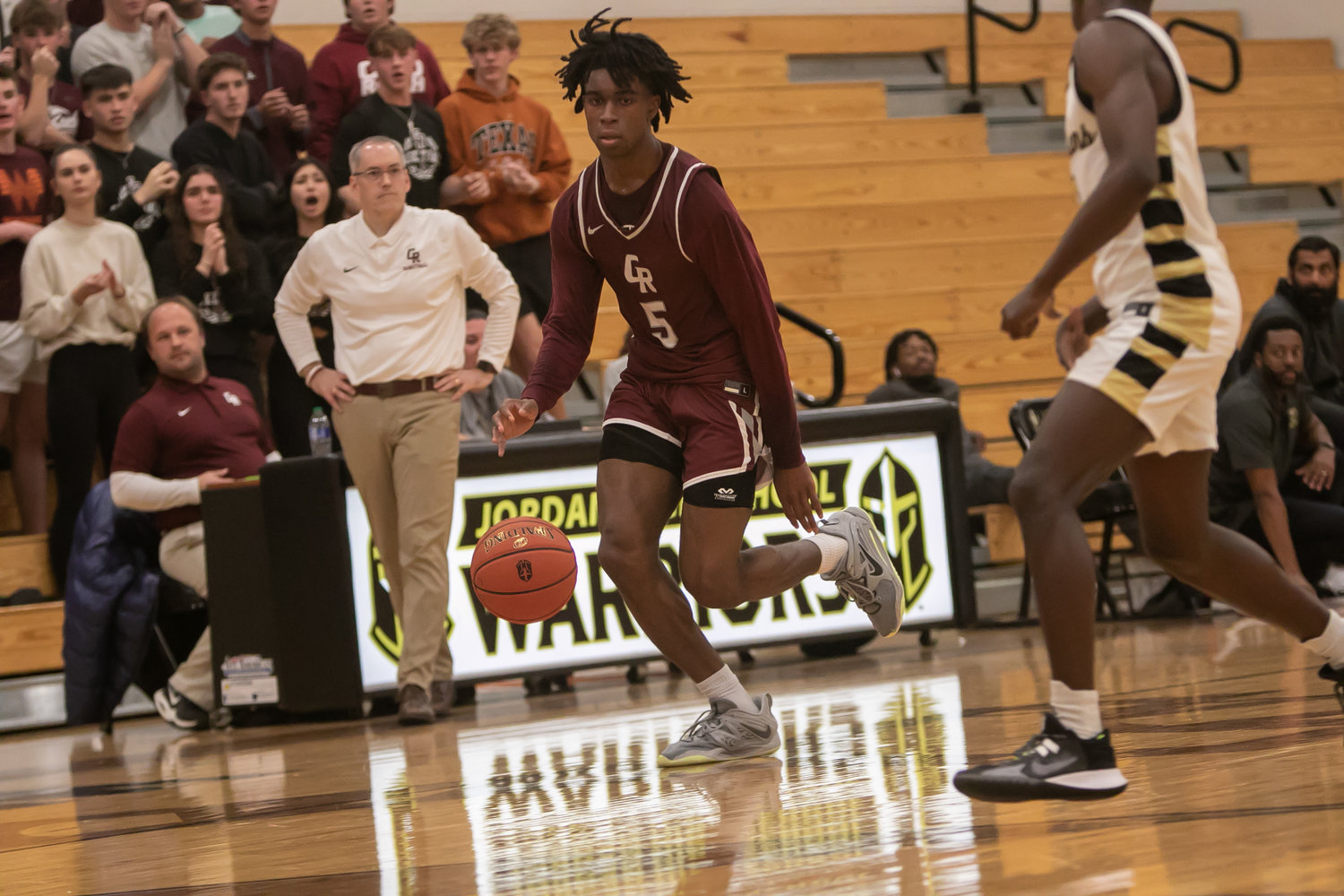 Emmanuel Gregory dribbles the ball down the court during Tuesday's game between Cinco Ranch and Jordan at the Jordan gym.