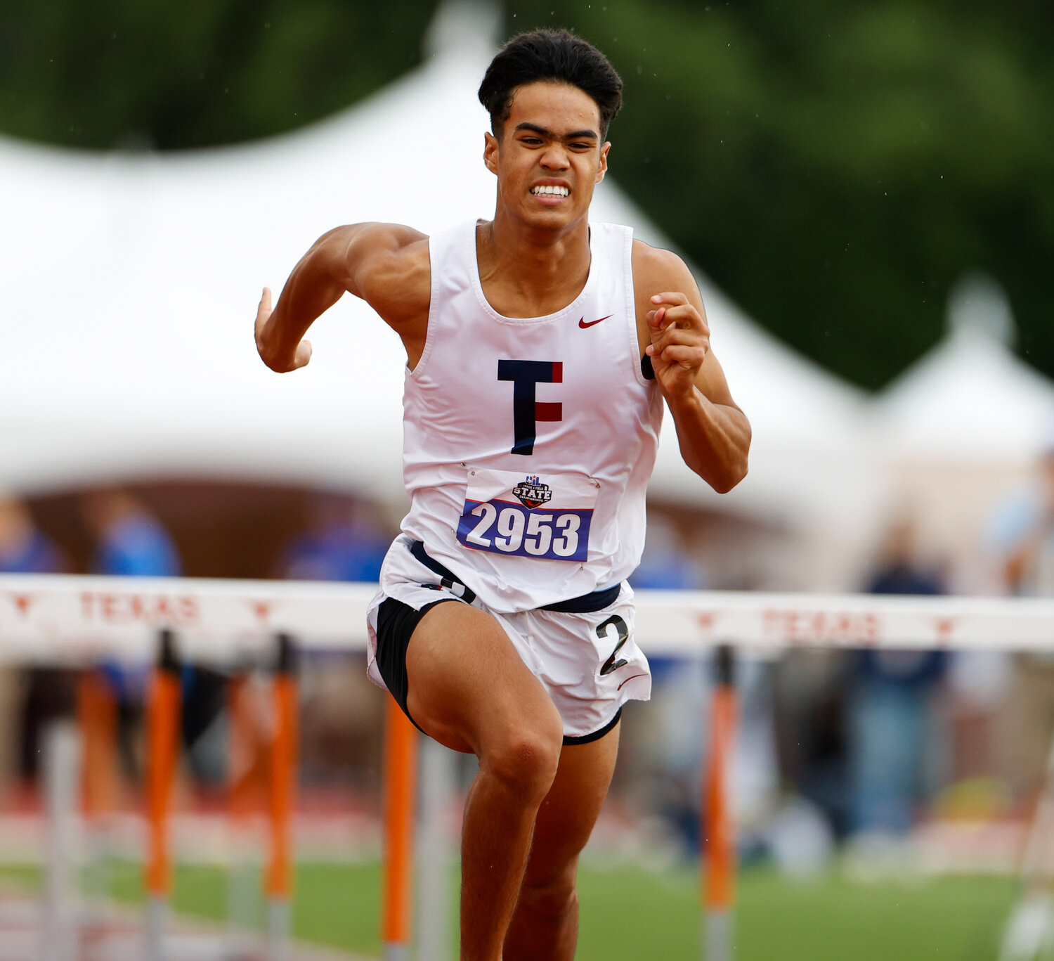 Jayden Keys of Tompkins High School (2953) crosses the finish line third, earning a bronze medal, in the Class 6A boys 110-meter hurdles during the UIL State Track and Field Meet on Saturday, May 13, 2023 in Austin.