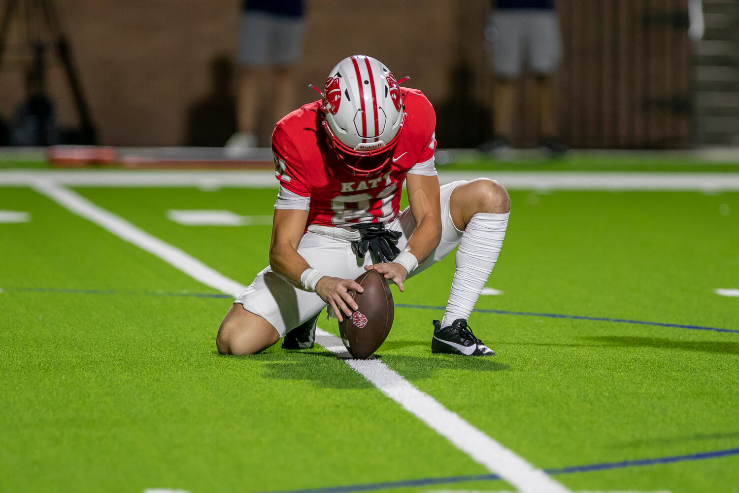 Carter Sears holds an extra point during Friday's game between Katy and Tompkins at Rhodes Stadium.