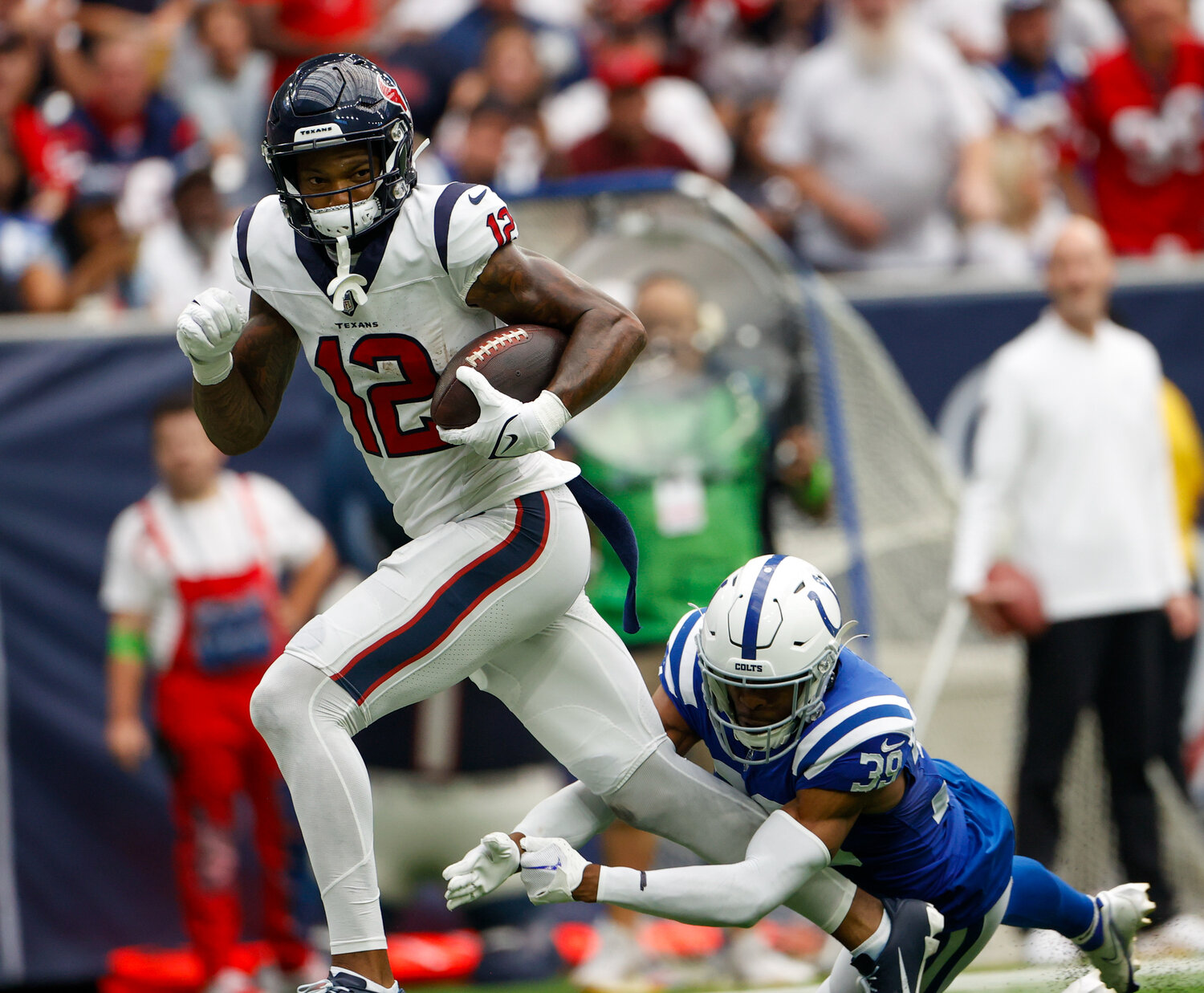 Texans wide receiver Nico Collins (12) runs through the tackle attempt of Colts cornerback Darrell Baker Jr. (39) during an NFL game between the Texans and the Colts on September 17, 2023 in Houston. The Colts won, 31-20.