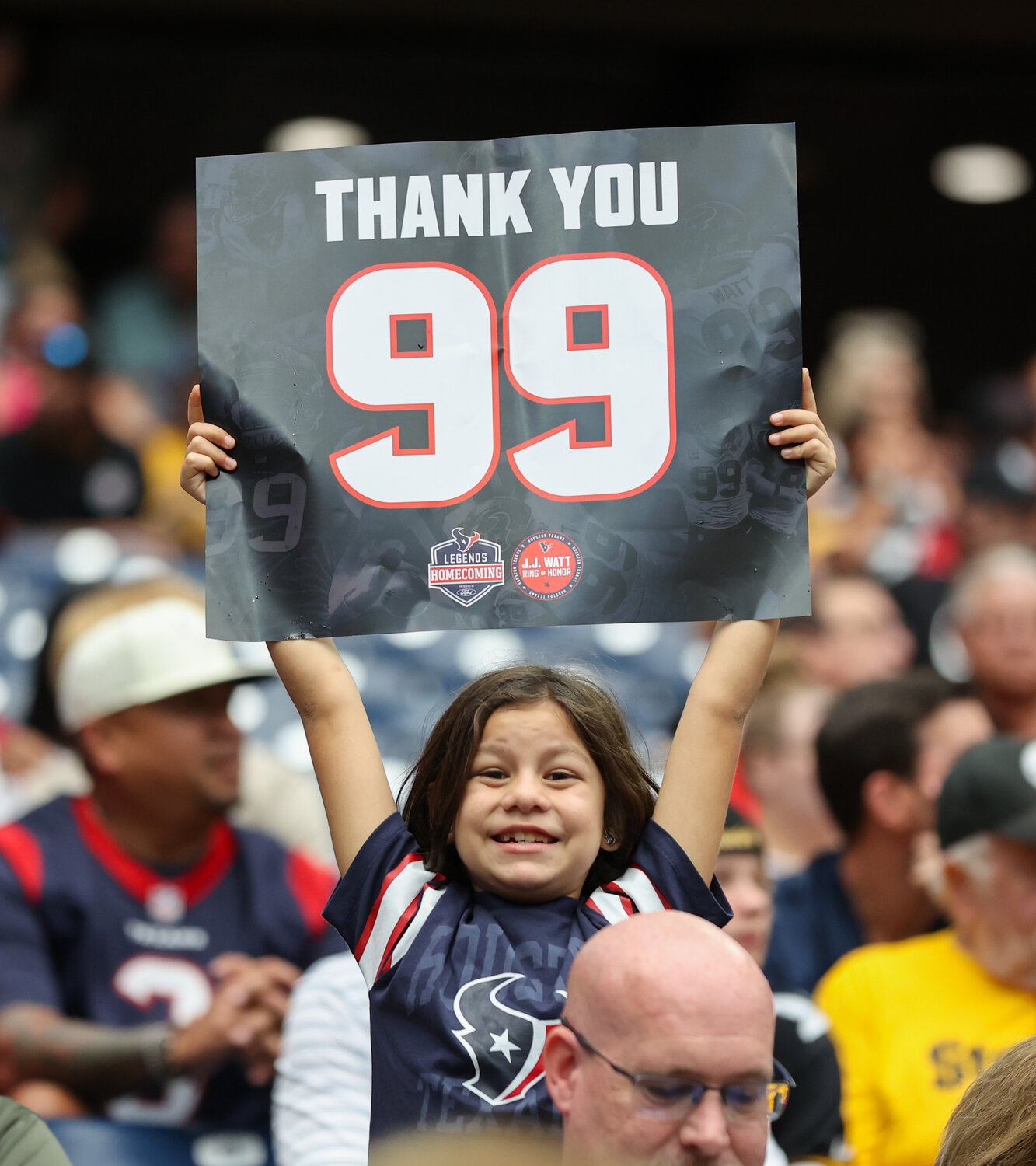 A young Houston fan holds up a sign for former Texans player JJ Watt during an NFL game between the Texans and the Steelers on October 1, 2023 in Houston. Watt was inducted into the Texans’ Ring of Honor at halftime.