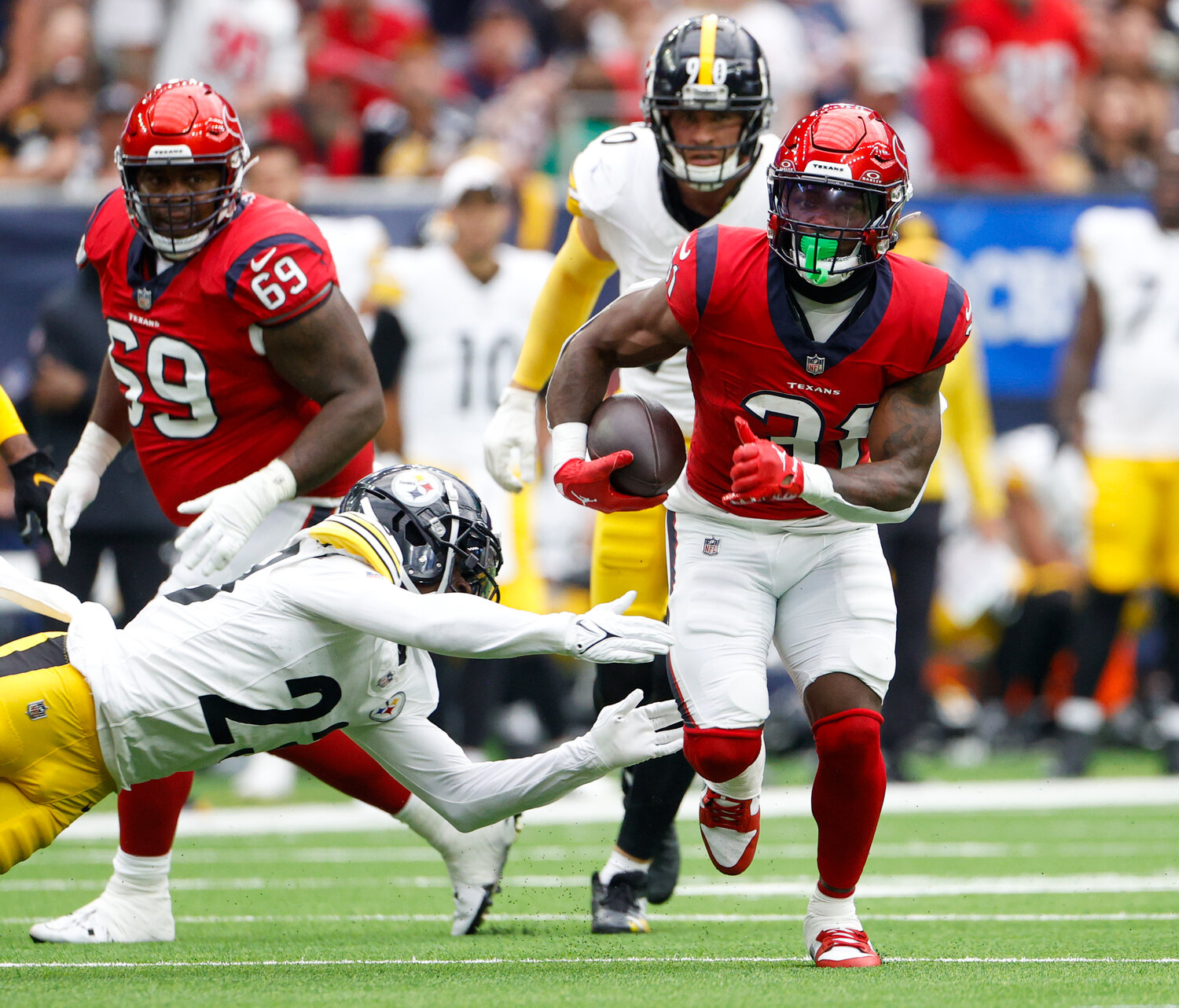 Texans running back Dameon Pierce (31) carries the ball past the outstretched arms of Steelers safety Damontae Kazee (23) during an NFL game on October 1, 2023 in Houston.