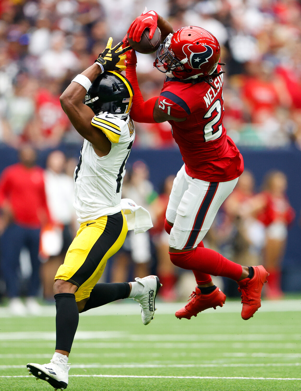 Texans cornerback Steven Nelson (21) leaps to intercept a pass intended for Steelers wide receiver Calvin Austin III (19) during an NFL game between the Texans and the Steelers on October 1, 2023 in Houston.