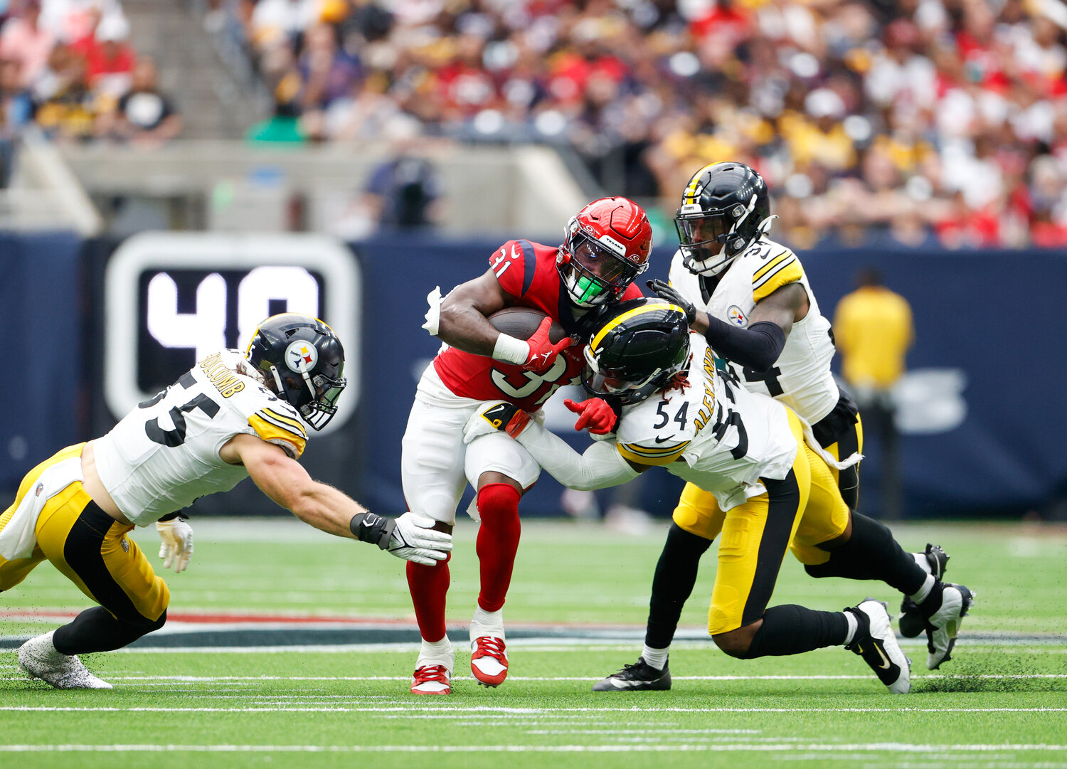Texans running back Dameon Pierce (31) carries the ball through contact with Steelers linebackers Cole Holcomb (55) and Kwon Alexander (54 during an NFL game between the Texans and the Steelers on October 1, 2023 in Houston.
