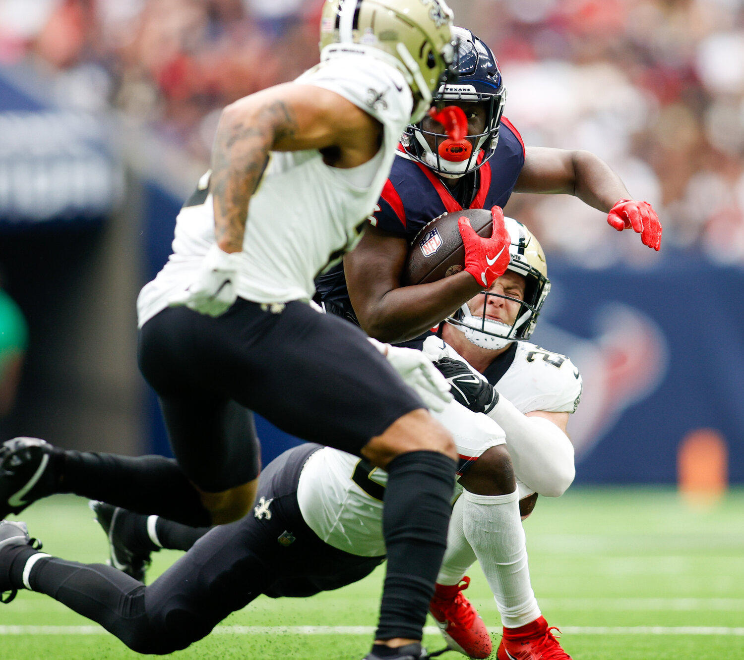 Saints linebacker Pete Werner (20) grabs on to make a tackle as Texans running back Devin Singletary (26) carries the ball during an NFL game between the Texans and the Saints on October 15, 2023 in Houston. The Texans won, 20-13.