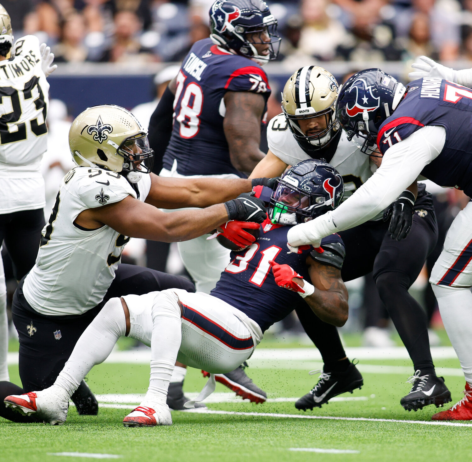 Saints defensive tackle Nathan Shepherd (93) grabs and pulls the ball as Texans running back Dameon Pierce (31) is tackled during an NFL game between the Texans and the Saints on October 15, 2023 in Houston. The Texans won, 20-13.