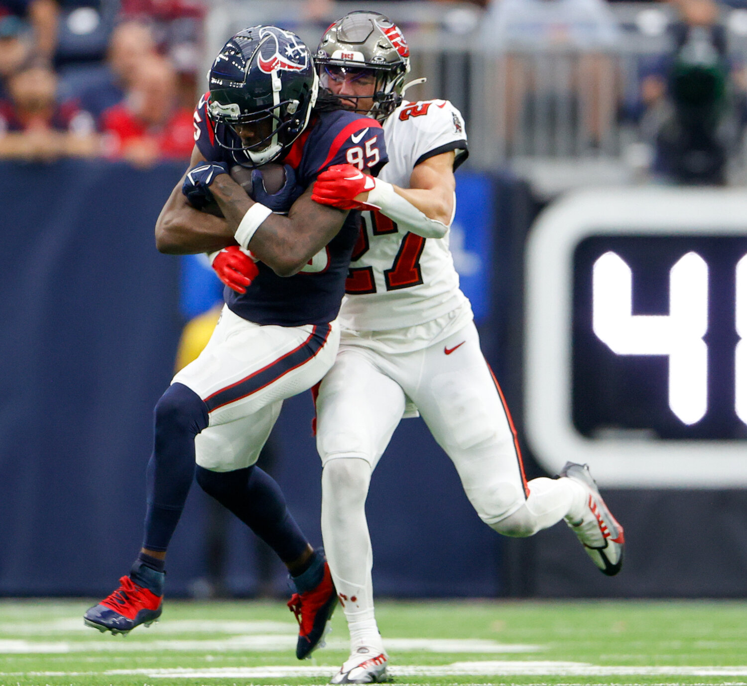 Buccaneers cornerback Zyon McCollum (27) tackles Texans wide receiver Noah Brown (85) after a catch during an NFL game between the Houston Texans and the Tampa Bay Buccaneers on November 5, 2023 in Houston.
