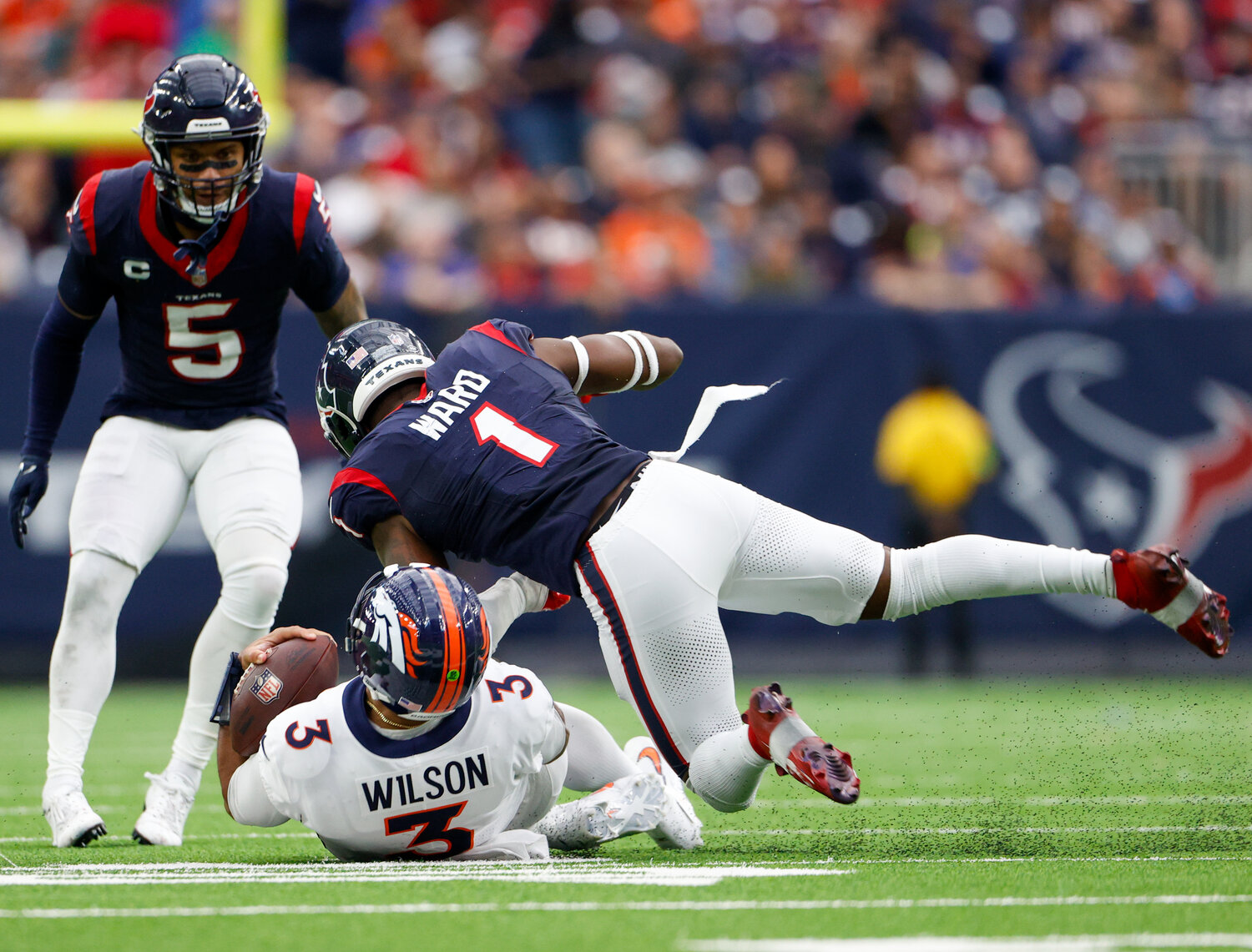 Texans safety Jimmie Ward (1) is flagged for unnecessary roughness for a hit on Broncos quarterback Russell Wilson (3) sliding on a carry during an NFL game on December 3, 2023 in Houston. The Texans won, 22-17.
