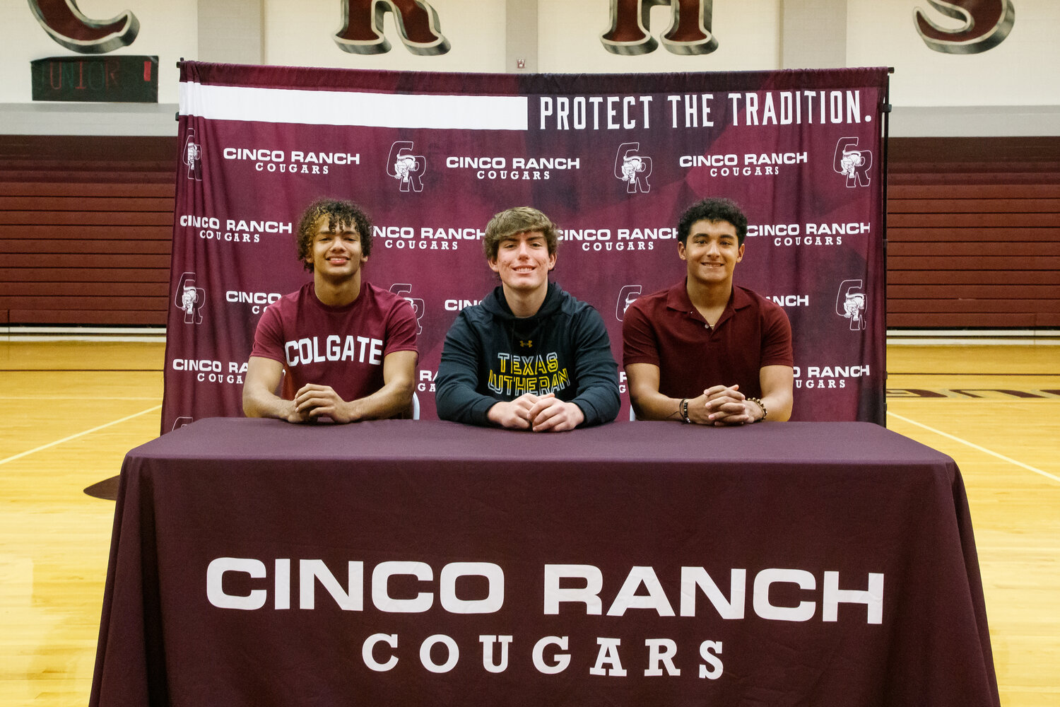 Taytum Johnson, Paul Acosta and Thomas Guy pose for a photo during the signing ceremony at Cinco Ranch High School.